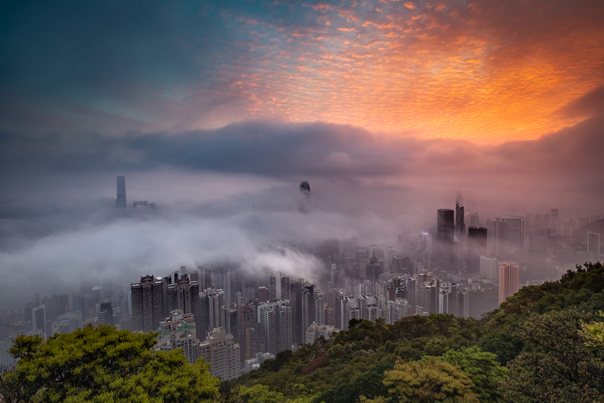 Sunrise glow decorates the city in fog