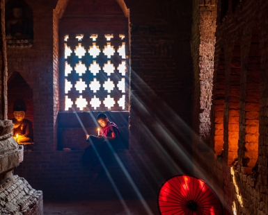 A novice reading a book in old temple